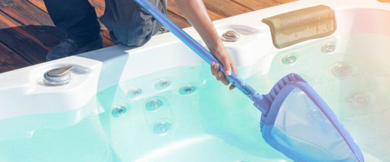 A person is performing hot tub service with a skimmer.